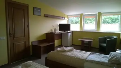 a bedroom with a bed and a desk with a television at Guest house 