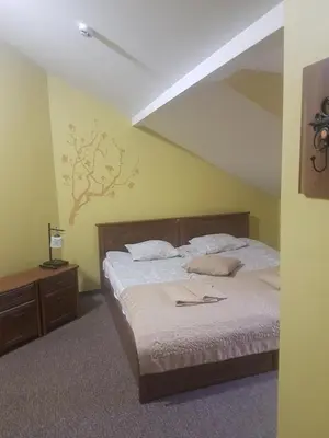 a bedroom with a bed and a tree on the wall at Guest house 