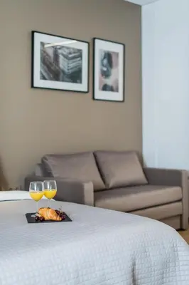 a table with two glasses of wine and a couch at River city apartments in Kaunas