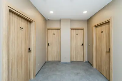 an empty corridor with wooden doors in a room at River city apartments in Kaunas