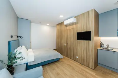 a bedroom with a bed and a sink and a tv at River city apartments in Kaunas