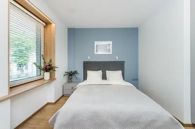 a bedroom with a large bed and a window at River city apartments in Kaunas