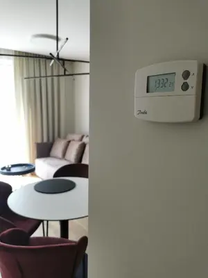 a clock on a wall next to a living room at MyCasa CBD in Vilnius