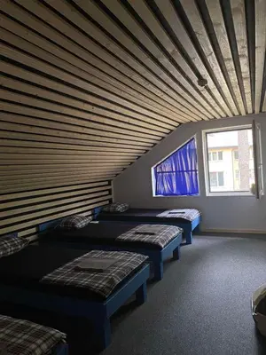 a room with three beds and a wooden ceiling at Palūšės Kempingas (kambariai) in Palūšė