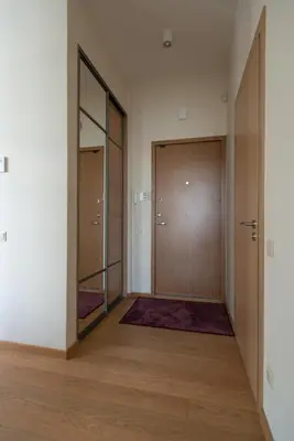 an empty hallway with two doors and a mirror at 39DO in Druskininkai