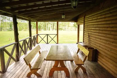 a wooden table and two chairs on a porch at Pas Kaziuką namas-sodyba in Ignalina