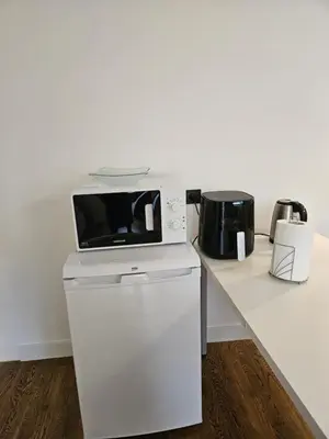 a microwave sitting on top of a white counter at Apartamentai Šilas in Druskininkai