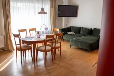 a living room with a table and chairs and a couch at Apartamentai Šilas in Druskininkai