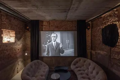 a room with a picture of a man on a screen at Bōheme House in Kaunas