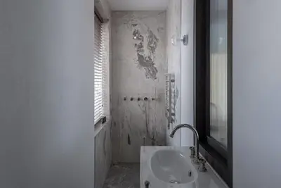 a white bathroom with a sink and a mirror at Bōheme House in Kaunas