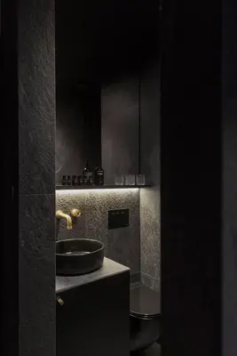a black bathroom with a sink and a counter at Bōheme House in Kaunas