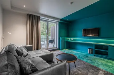 a living room with a couch and a tv at ESE HOTEL in Birštonas