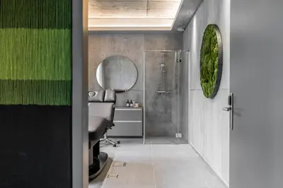 a bathroom with a shower and a chair and a mirror at ESE HOTEL in Birštonas