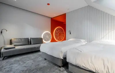 a bedroom with two beds and a couch in it at ESE HOTEL in Birštonas