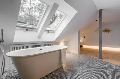 a bath tub in a bathroom with two windows at ESE HOTEL in Birštonas