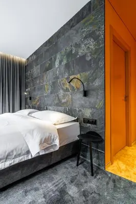 a bedroom with a bed and a brick wall at ESE HOTEL in Birštonas