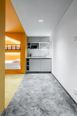 an attic bedroom with yellow walls and a bed at ESE HOTEL in Birštonas