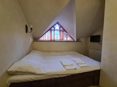 a bed in a room with a small window at Meldynas in Vabalninkas