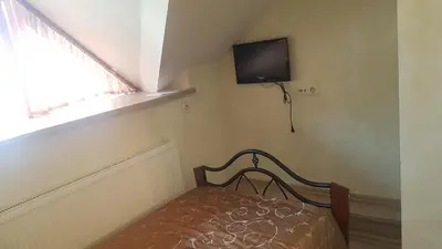 a bedroom with a bed and a tv on the wall at Meldynas in Vabalninkas