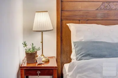 a lamp on a table next to a bed at Old Town Saviciaus street Apartment in Vilnius