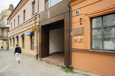 a man walking into a building on a street at Domus Fortuna in Vilnius