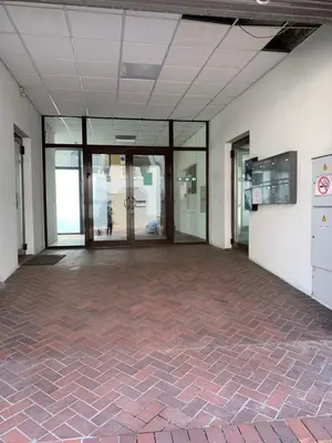 an empty room with a brick floor and glass doors at Domus Fortuna in Vilnius