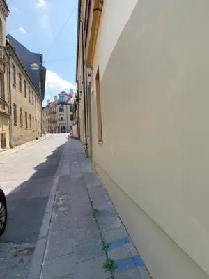 an empty street in an alley with a white wall at Domus Fortuna in Vilnius