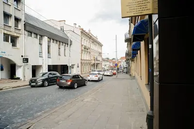 a city street with cars parked on the street at Domus Fortuna in Vilnius