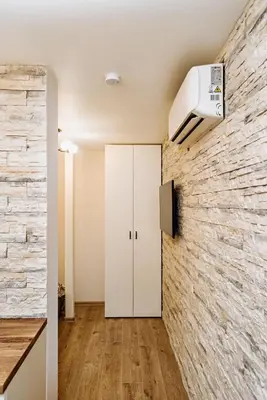 a room with a white cabinet and a brick wall at Domus Fortuna in Vilnius