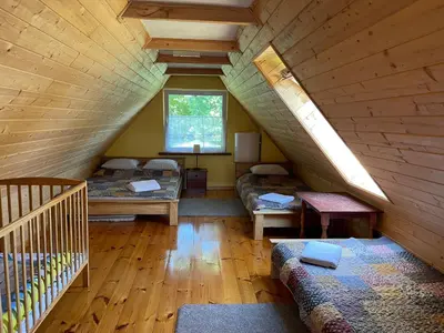 a attic room with two beds and a staircase at Gintaro sodyba in Lazdijai