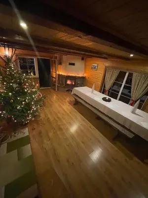 a living room with a large bed and a christmas tree at Gintaro sodyba in Lazdijai