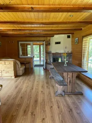 a large living room with a large wooden table at Gintaro sodyba in Lazdijai