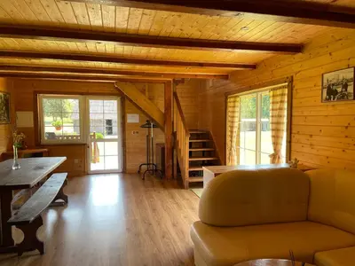 a living room with a couch and a wooden ceiling at Gintaro sodyba in Lazdijai