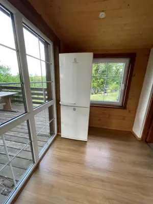 a white refrigerator in a room with windows at Gintaro sodyba in Lazdijai
