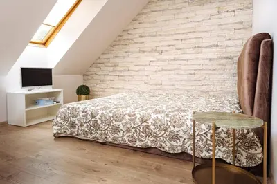 a bedroom with a bed and a brick wall at RBRoom in Vilnius
