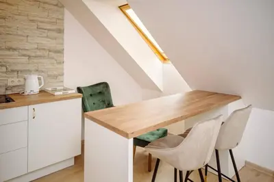 a kitchen with a wooden table and two chairs at RBRoom in Vilnius