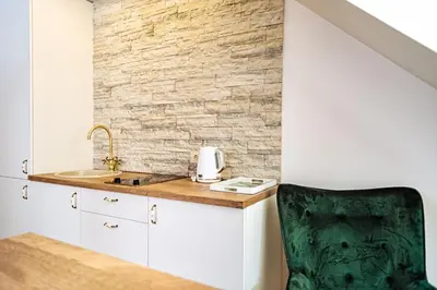 a kitchen with a sink and a green chair at RBRoom in Vilnius