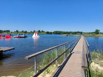 a dock with two boats on a lake at Naktakės apartamentai in Kupiškis
