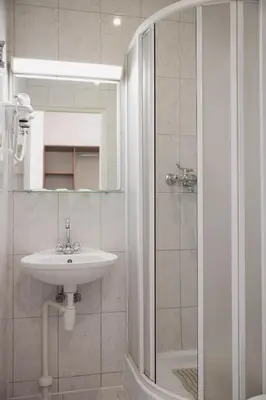 a white bathroom with a sink and a shower at Motelis Gariūnai in Vilnius
