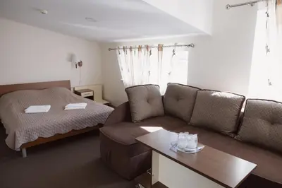 a living room with a couch and a bed at Motelis Gariūnai in Vilnius
