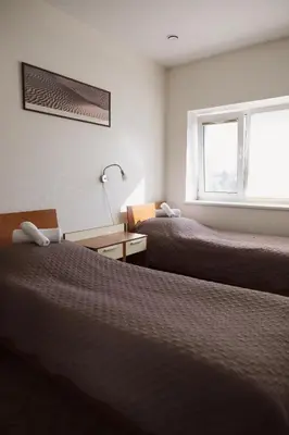 a hotel room with two beds and a window at Motelis Gariūnai in Vilnius