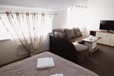 a hotel room with a couch and a tv at Motelis Gariūnai in Vilnius