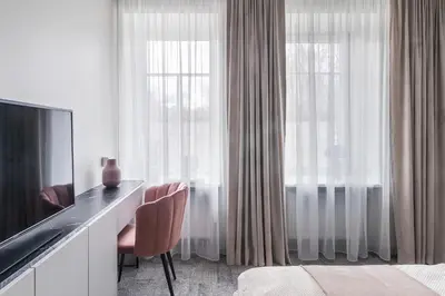 a hotel room with a desk and two windows at Place No. 2 in Vilnius