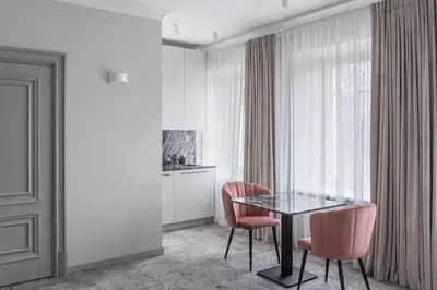a dining room with a table and two pink chairs at Place No. 2 in Vilnius