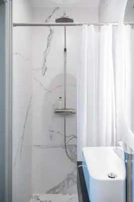 a white bathroom with a shower and a sink at Place No. 2 in Vilnius