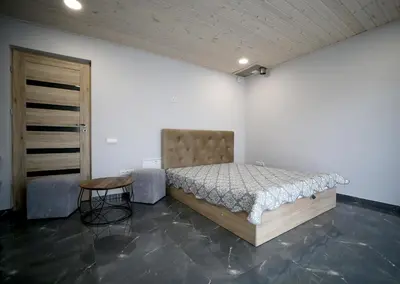 a bedroom with a bed and a stool and a door at Kėdainiai Old town apartment in Kėdainiai