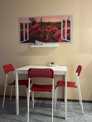 a white table with chairs and a picture of red flowers at Comfortable Townhouse in Vilnius