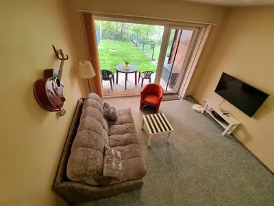 a living room with a couch and a television and a table at Comfortable Townhouse in Vilnius