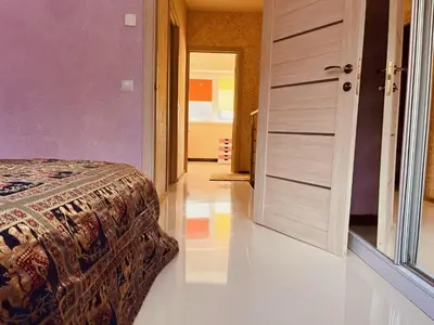 a bedroom with a bed and an open door at Comfortable Townhouse in Vilnius