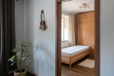 a bedroom with a bed and a guitar on the wall at G & M Apartamentai in Anykščiai